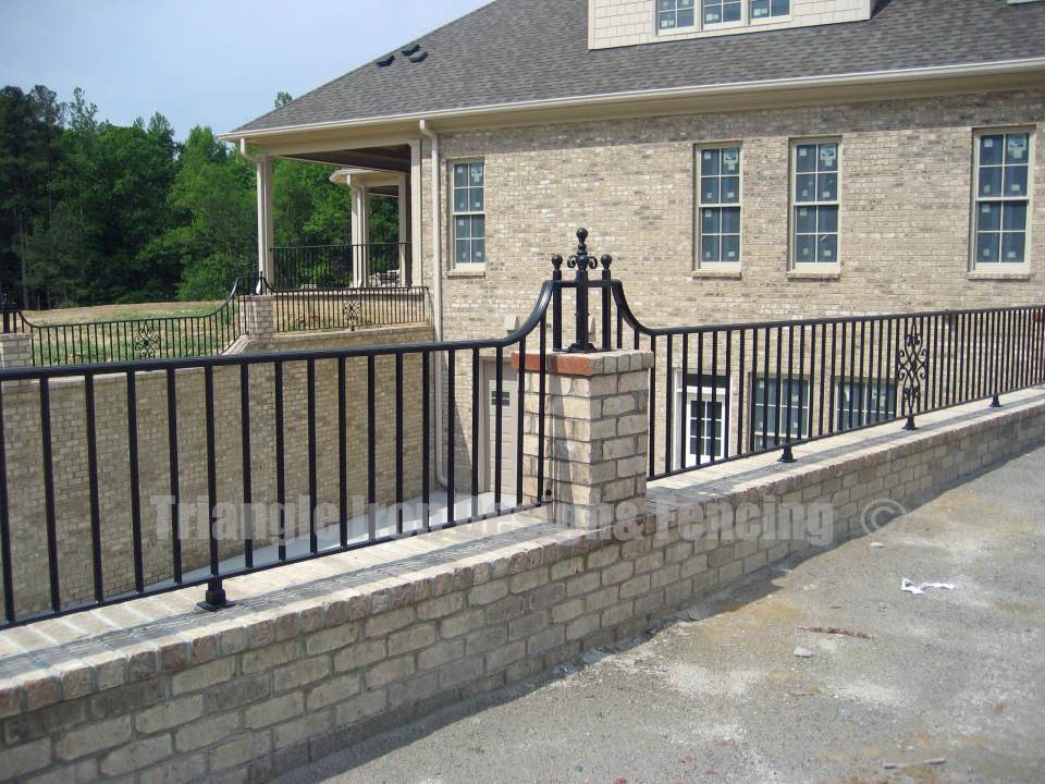 custom iron fencing installed in the wall outside house