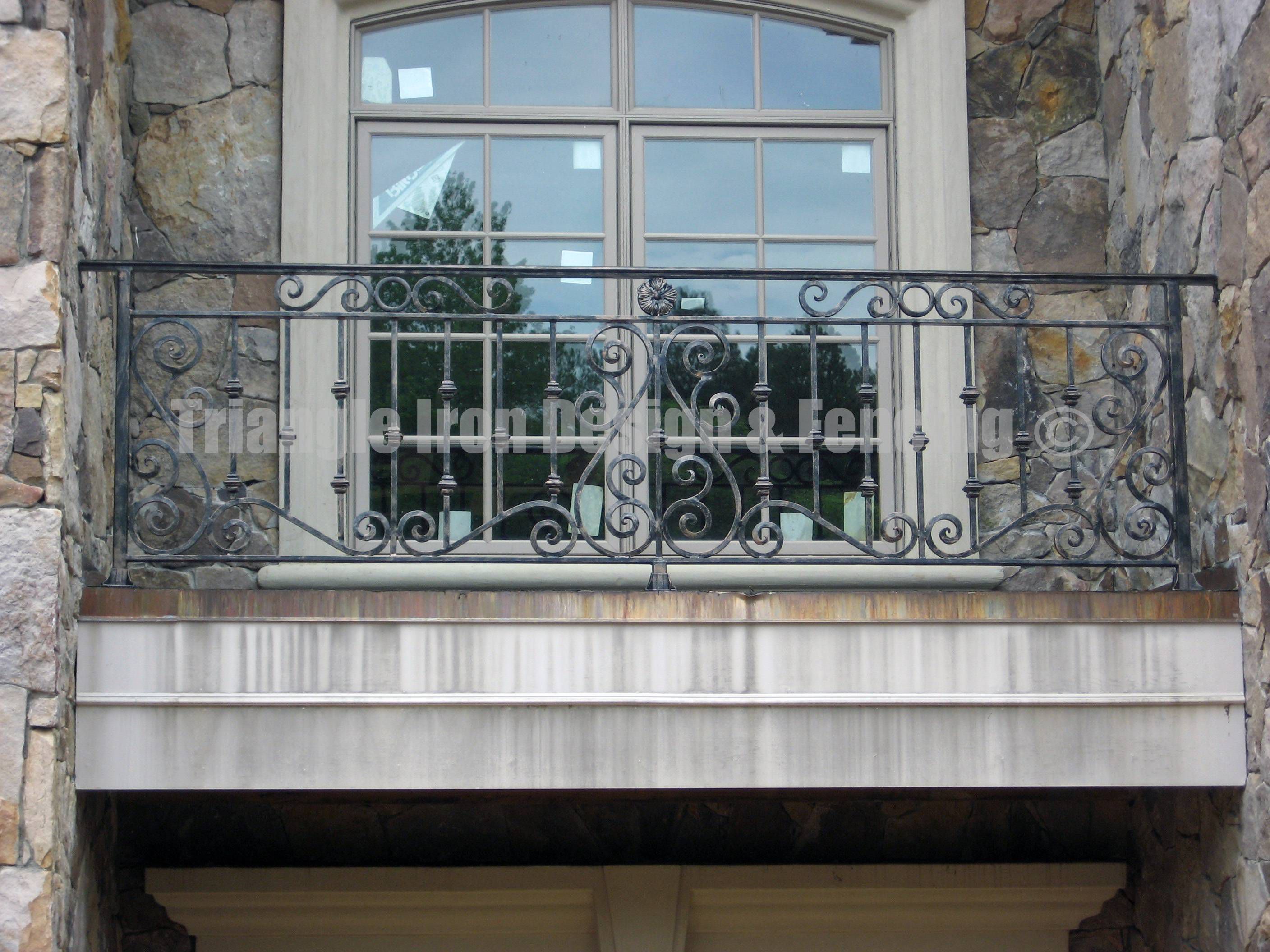 closeup view of the iron railing at the balcony near glass door gate